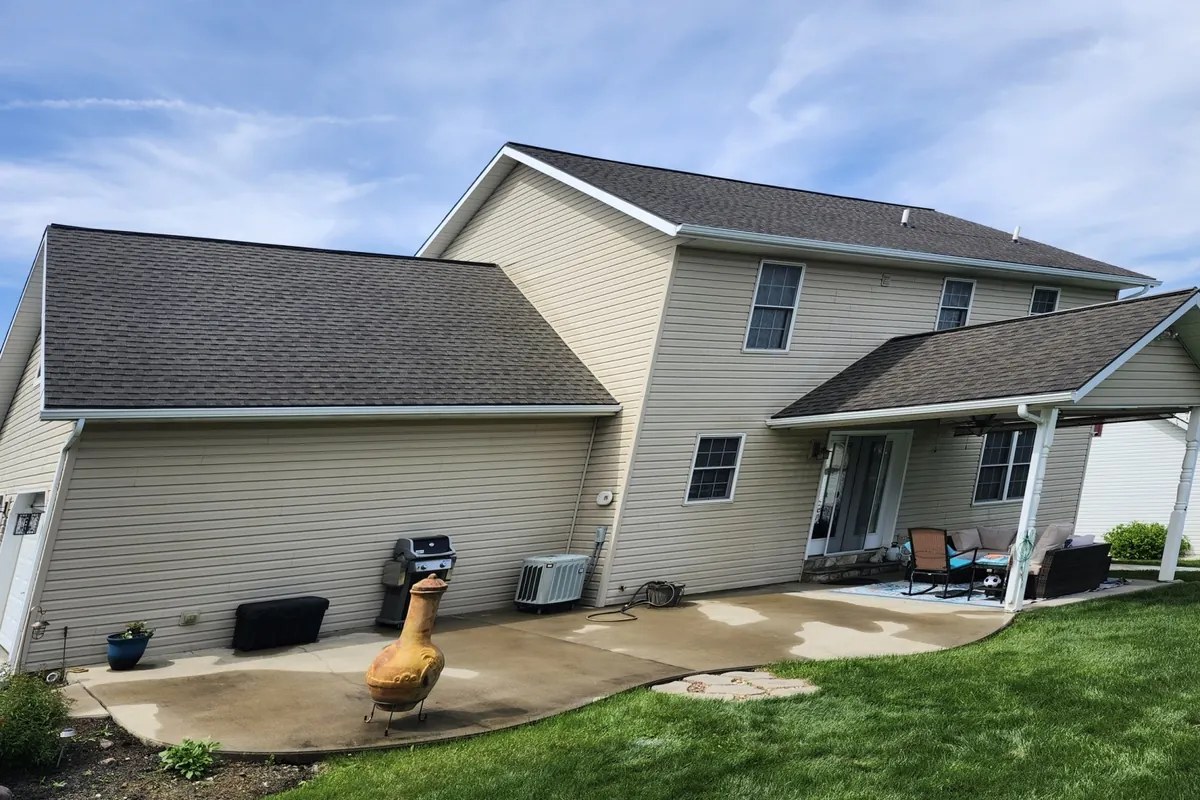 Same two-story home after soy roof rejuvenation, with deep, even dark charcoal asphalt shingles