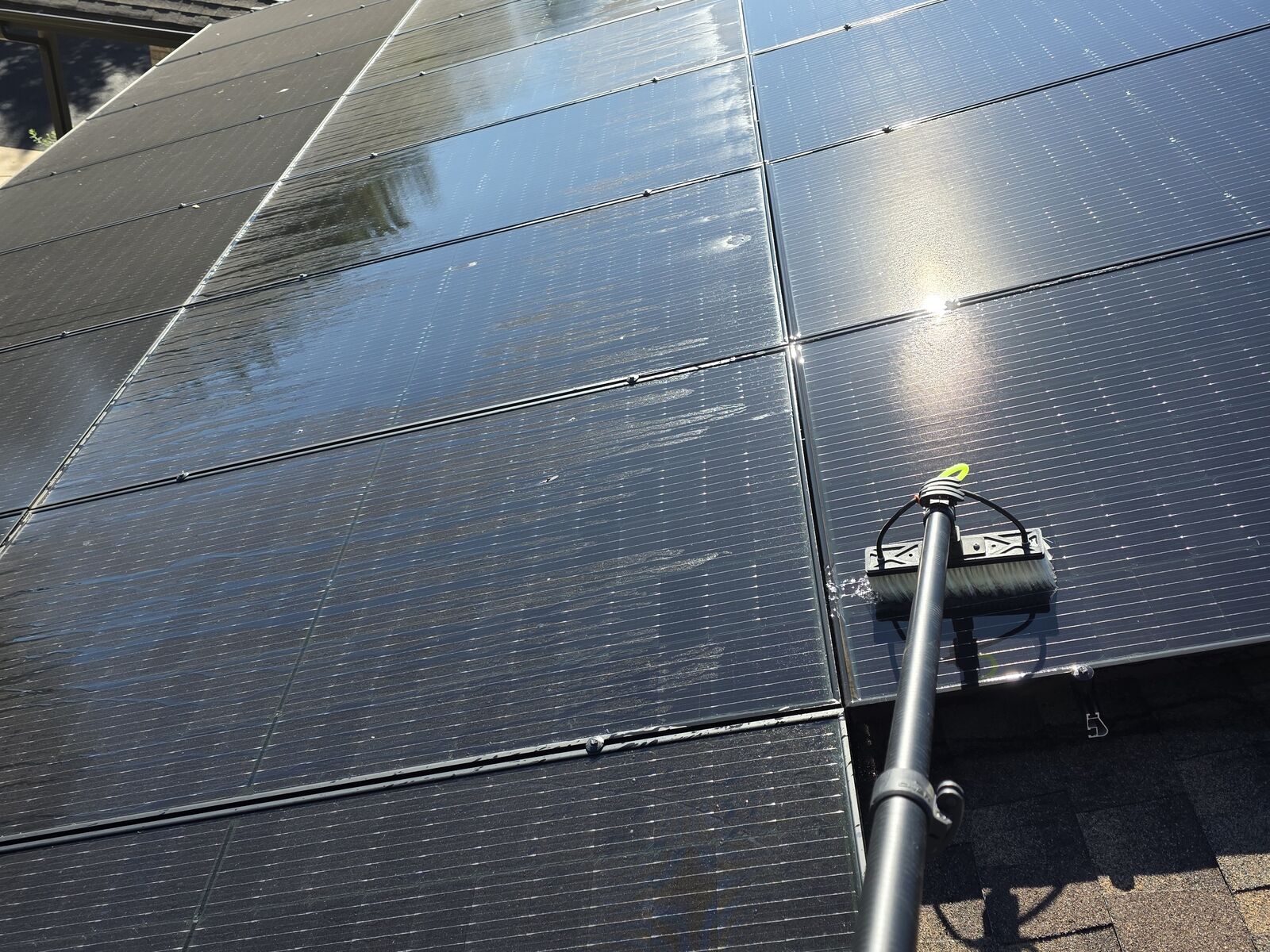 Power Play cleaning rooftop solar panels with a water-fed pole